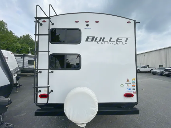 Rear view of a white Bullet Ultra Lite by Keystone travel trailer, perfect for your next RV rental adventure.. Keystone Bullet 2023