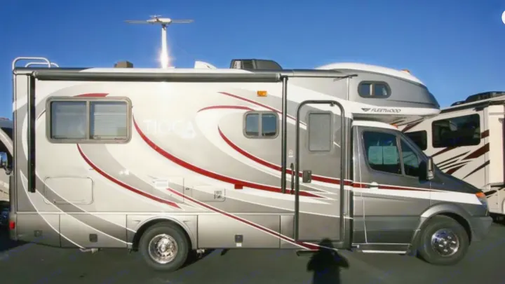 A sleek, grey Fleetwood Tioga Class C RV, ideal for an RV rental. Features a rooftop antenna and modern design for travel.. Fleetwood Tioga 2011