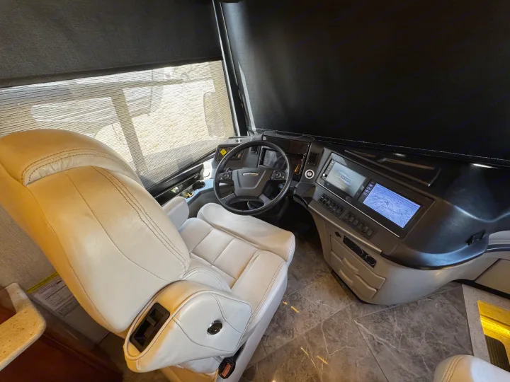 Luxury RV rental: Driver's cockpit with plush captain's chair, Freightliner steering, and digital displays.. New Aire New Aire Motorhome 2020