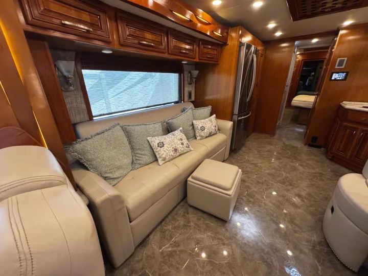 Step inside this luxury RV rental! Enjoy a spacious living area with comfortable sofa, elegant wood cabinetry, and gleaming tile floor.. New Aire New Aire Motorhome 2020