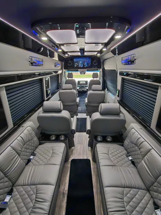 Inside this luxury RV rental: comfortable grey seating, wood-look floor, and elegant lighting. Perfect for executive travel.. Ultimate Toys Ultimate Coach 2026