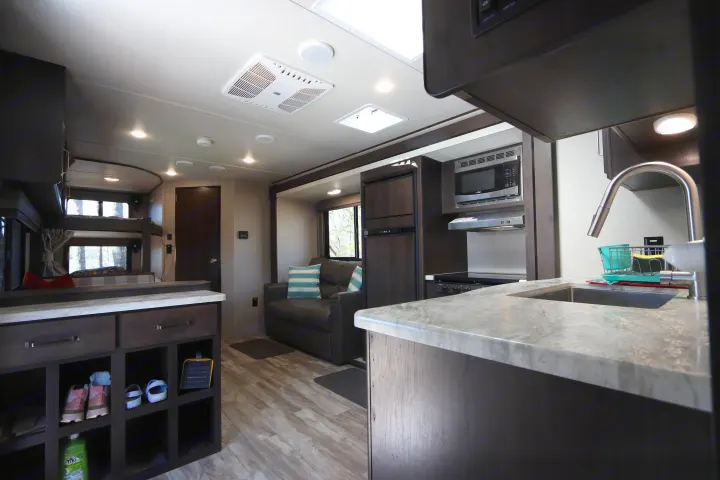 Spacious RV rental interior featuring a modern kitchen, comfortable living area, and bunk beds.. Grand Design Transcend Xplor 2020