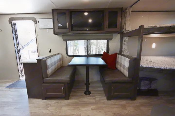 Cozy RV rental interior with dinette, bunk beds, and lake view. Perfect for glamping getaways.. Grand Design Transcend Xplor 2020