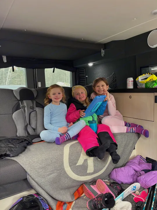 Three happy girls cozy up in an RV rental, surrounded by ski gear after a fun family adventure.. Pleasure-Way Pleasure-Way Class B 2022
