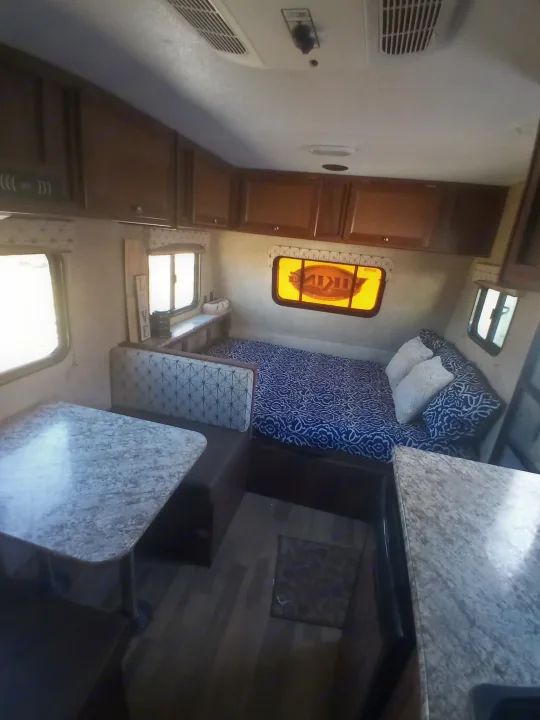 Explore this comfy rv rental interior: dinette, bed, kitchen, cabinets, and bright windows offer a great travel space.. Coachmen Viking 2017