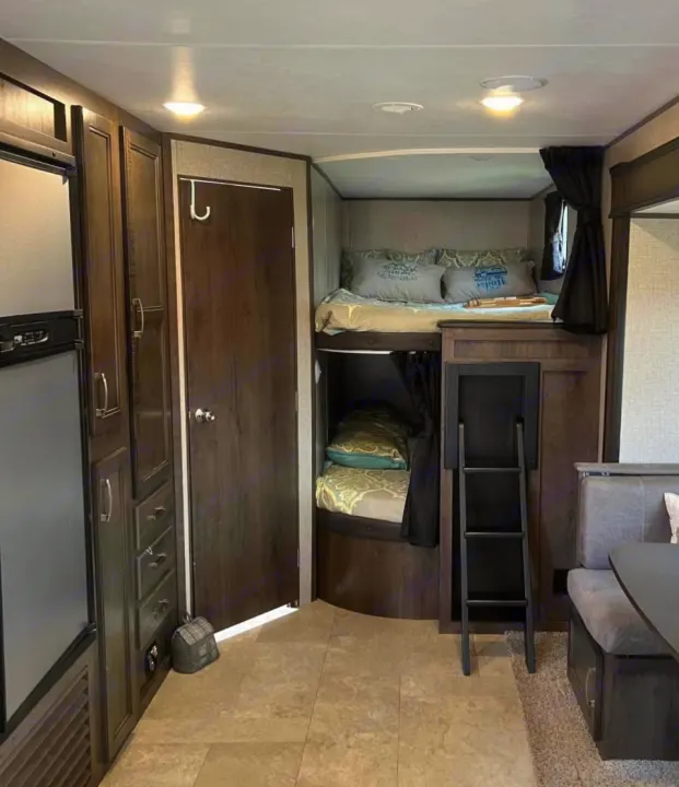 Spacious RV rental interior: view of bunk beds, functional kitchen area, and dinette. Ideal for comfortable camper travel.. Jayco Jay Flight SLX 2021