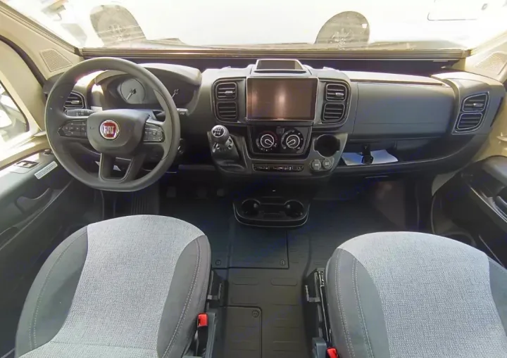 Interior of an RV rental: driver's cabin with Fiat steering wheel, touchscreen display, manual gear, and comfortable front seats.. Challenger C194 START EDITION 2025