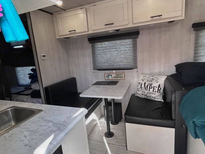 RV rental: Bright interior featuring a dinette with black benches, marble-look table, and white cabinets.. Genesis Supreme 16 BB 2024
