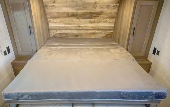 Cozy RV rental bedroom with plush grey mattress, wooden headboard, and storage cabinets for comfortable travel.. Gulf Stream 248BH 2022