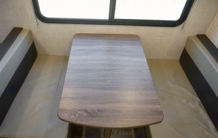 RV rental dinette area featuring a gray wood-grain table and upholstered bench seats, ideal for travelers.. Gulf Stream 248BH 2022