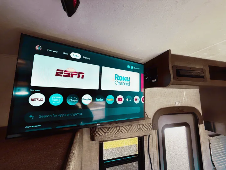 An RV rental entertainment setup with a TCL smart TV displaying various streaming apps like Netflix and ESPN.. Coachmen Orion 2020