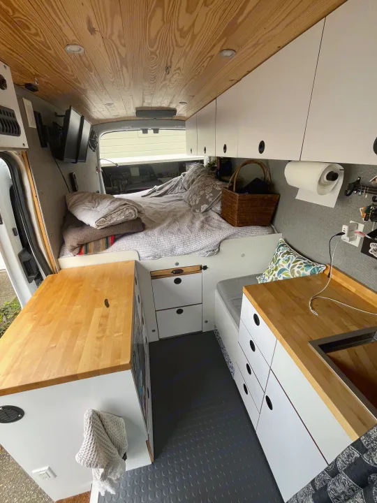 Spacious camper van interior, ideal for your next rv rental. Features comfy bed, kitchen, storage, and wooden ceiling.. Ford Custom Transit 2019