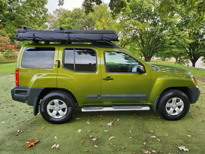 Bright green Nissan Xterra SUV with 'Antidote' roof-top tent, ideal for an RV rental camping adventure.. Nissan XTerra 2012