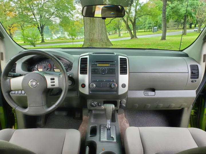 Driver's view: Nissan SUV interior dashboard with park and lake scene outside. Perfect for your next rv rental adventure.. Nissan XTerra 2012