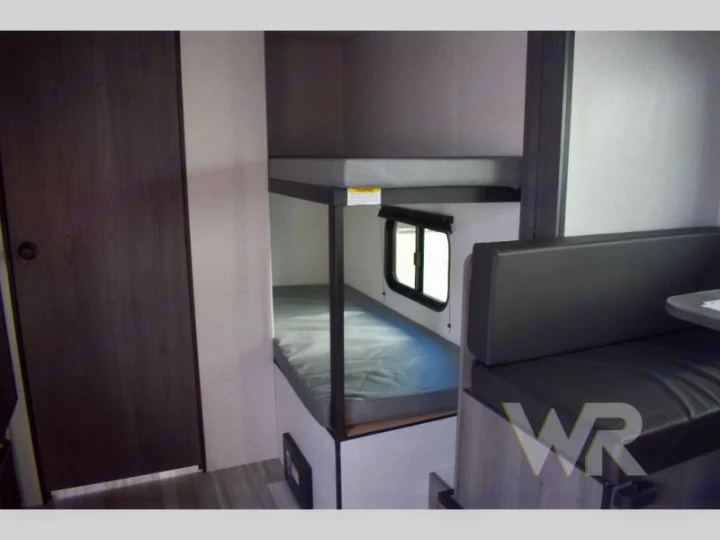 RV rental: Bright interior featuring comfortable bunk beds, a dinette, and a private door. Ideal for family adventures.. Keystone RV Hideout Sport 2024