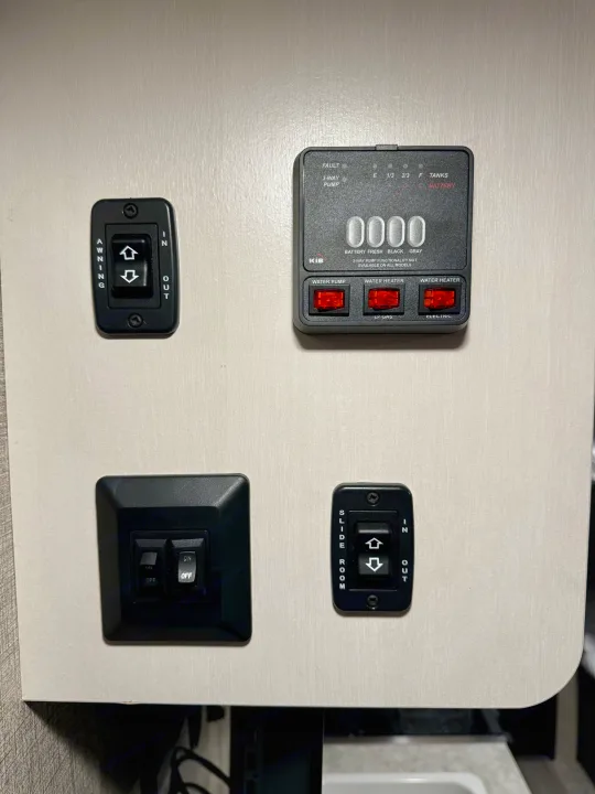 RV rental control panel with switches for awning, slide room, water pump, and water heater, plus tank level indicators.. Jayco Jay Flight SLX 2022