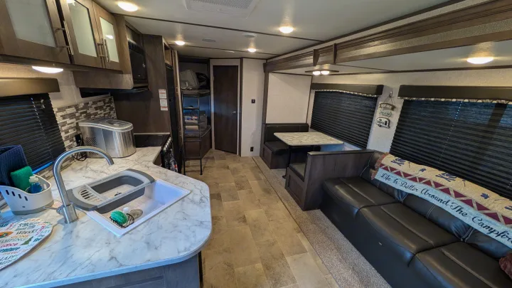 Experience this RV rental's inviting interior: a full kitchen, cozy dinette, and spacious living area with a comfortable sofa.. Dutchmen Coleman Lantern LT 2021