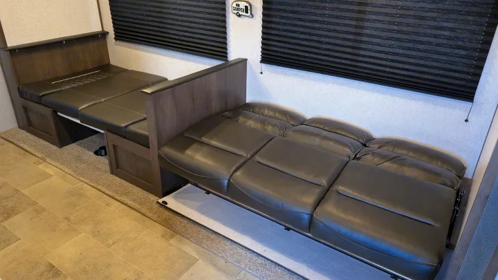 Spacious RV rental interior featuring versatile convertible dinette seating and an extended sofa bed for comfort.. Dutchmen Coleman Lantern LT 2021