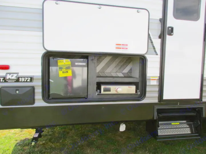 This RV rental features an open exterior compartment with a mini-fridge and pull-out griddle, ideal for outdoor camping meals.. KZ 332BHKSE 2022