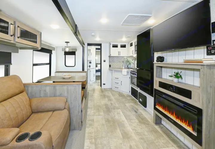 Experience a spacious, modern RV rental interior featuring a living area, kitchen, dinette, and entertainment center with fireplace. Ideal for travel.. Palomino Puma 337BH 2025