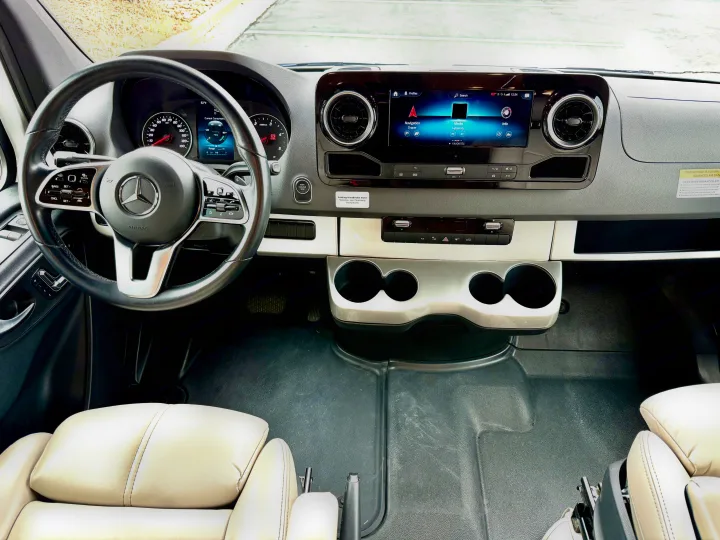 RV rental Mercedes-Benz van interior. Driver's view of the modern dashboard, infotainment system, and steering wheel.. Thor Tiburon 2022