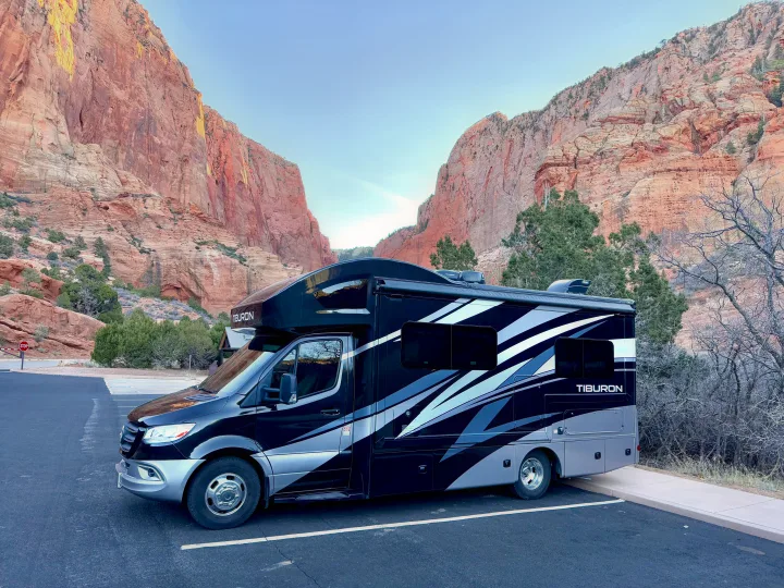 Scenic RV rental parked in a canyon, surrounded by majestic red rock mountains. Perfect for outdoor adventure!. Thor Tiburon 2022