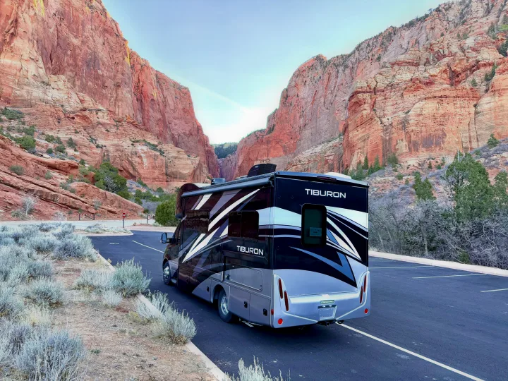 Tiburon RV rental ready for adventure, parked in a stunning canyon setting with towering red rock walls.. Thor Tiburon 2022