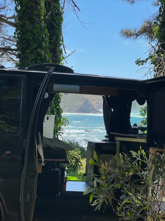 Coastal escape! This RV rental offers an immersive view of the ocean & cliffs from its open side door, blending nature with interior comfort.. Chevrolet AWD Express 2003