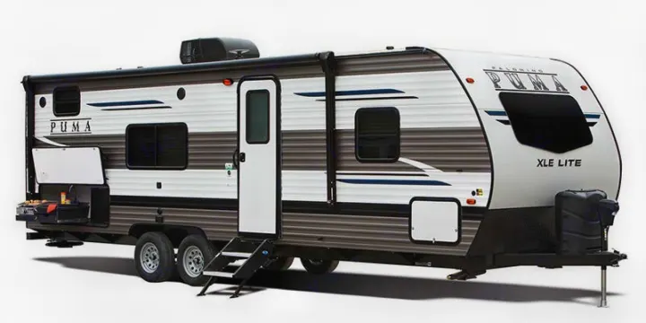 White and gray Puma XLE Lite travel trailer, a popular choice for RV rental. Equipped with an outdoor kitchen, ready for your next adventure.. Forest River Palomino Puma XLE 2022