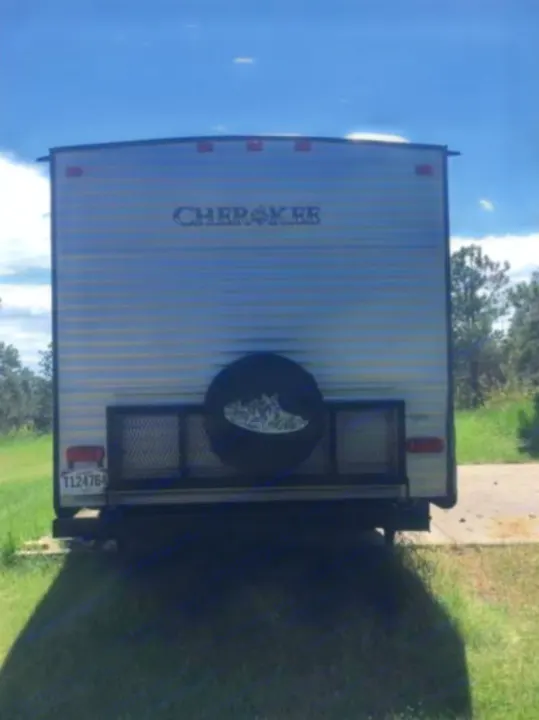 Rear view of a Cherokee travel trailer RV rental, featuring a spare tire & cargo rack. Ready for your next adventure.. Forest River Cherokee 2015