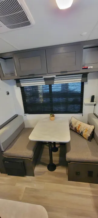 Modern rv rental dinette with cozy booth seating, table, and ample overhead cabinets. Ideal for dining & relaxation on the road.. Heartland RVs Mallard Pathfinder 2022