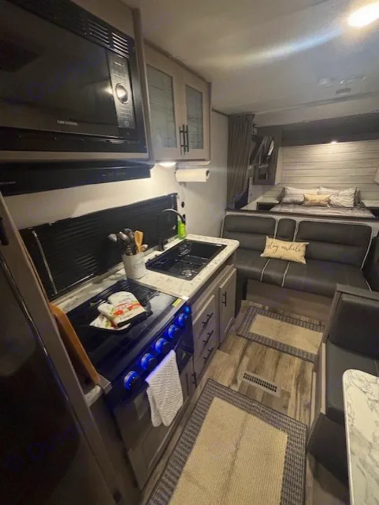 This RV rental shows a compact kitchen, dining area, and cozy bed, providing a full living space for your adventures.. Coleman Lantern 2024