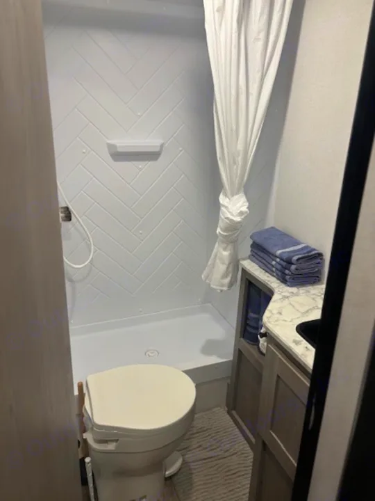Compact RV rental bathroom with shower, toilet, and vanity. Clean amenities for your travels.. Coleman Lantern 2024