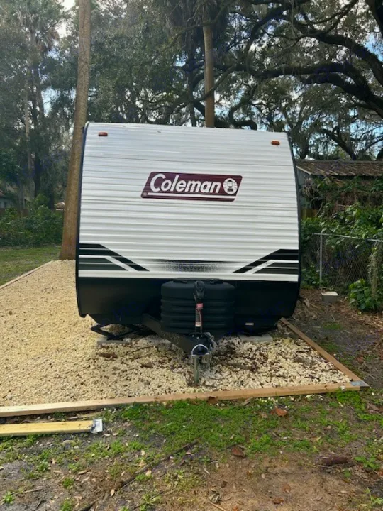 RV rental: White Coleman travel trailer on a prepared gravel site, ready for use.. Coleman Lantern 2024