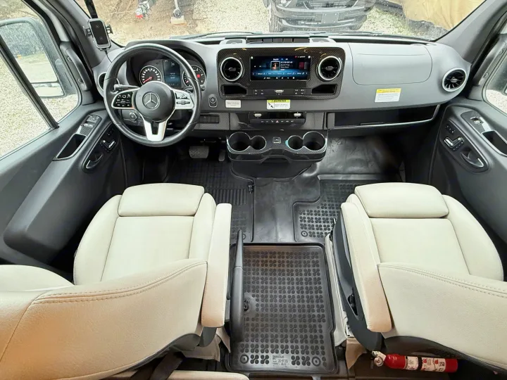 Spacious RV rental cabin interior featuring driver's area, modern dashboard, infotainment system, and comfortable front seats.. Winnebago Era 2020
