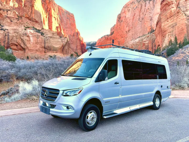 An RV rental Mercedes-Benz camper van parked against stunning red rock canyon walls. Ideal for scenic adventures.. Winnebago Era 2020