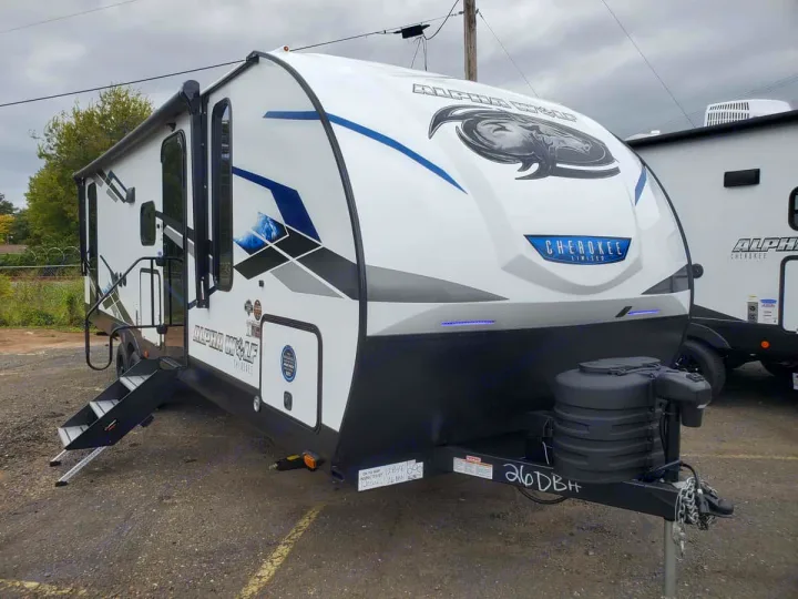 This Alpha Wolf travel trailer, a white RV with blue accents, steps, and awning, is ready for rv rental and your next adventure.. Forest River Cherokee Alpha Wolf 2024