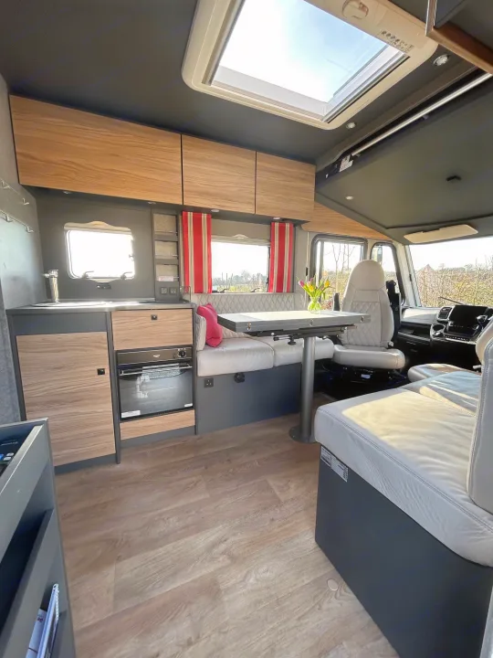 This RV rental offers a modern interior with a well-equipped kitchenette, dining area, and comfortable seating.. GlamperRV DBL 2026
