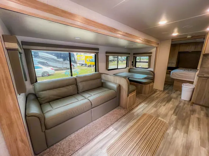 Step inside this spacious RV rental interior, complete with a comfy couch, dinette, and bedroom area. Perfect for your adventures!. Winnebago Minnie Winnie 2021