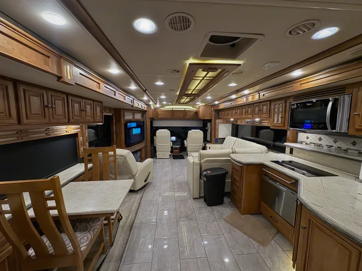 Spacious, luxurious RV rental interior with kitchen, dining, and living areas, offering comfort on the road.. Winnebago Ellipse 2016