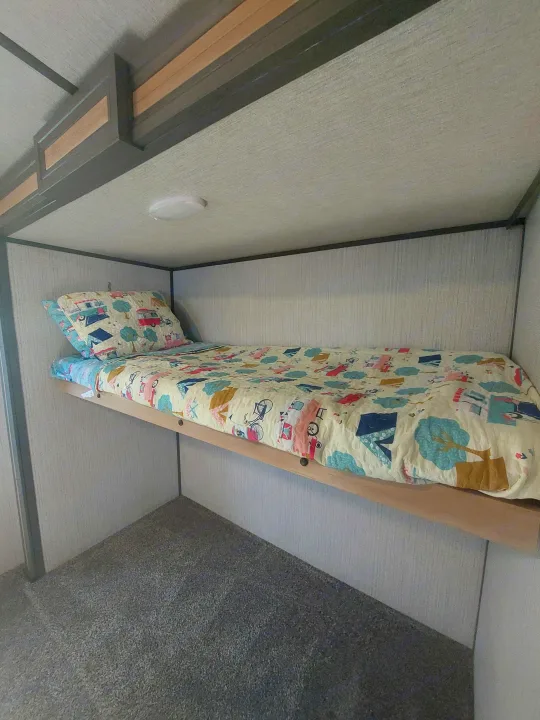 Step inside this cozy RV rental's bunk bed area, featuring a colorful, playful quilt for a comfortable night's sleep.. Cruiser RV Radiance Ultra Lite 2020