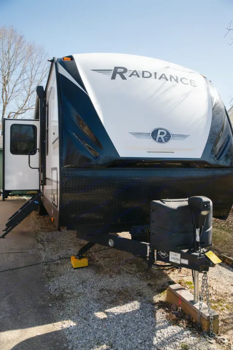 A Radiance travel trailer, ready for adventure. This RV rental features an open door & steps, parked on gravel.. Cruiser RV Radiance Ultra Lite 2020