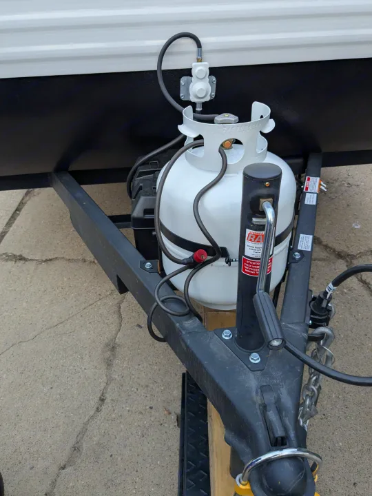 Front of an RV rental: Dual propane tanks, regulator, and trailer hitch setup. Ready for your next adventure.. Keystone Coleman 2025
