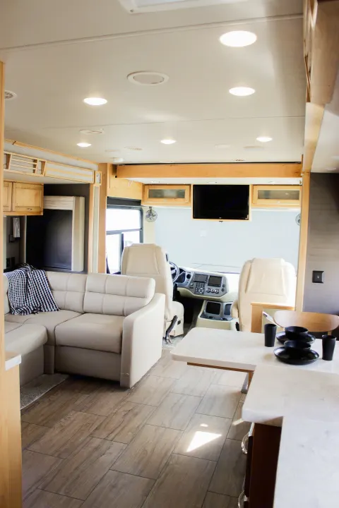 Experience a modern RV rental! View the clean, spacious motorhome interior featuring a living area, driver's cockpit, and kitchen.. Allegro Allegro Open Road 2021