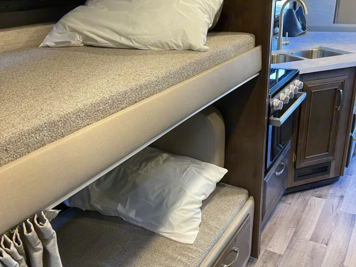 RV rental interior: Comfortable bunk beds and a compact kitchen offer cozy living for your next adventure.. Jayco Redhawk 2022