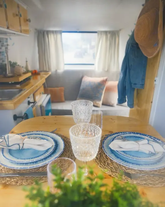Step inside this cozy RV rental! Features a dining table set for two, compact kitchen, and lounge area.. Boler Boler 1974
