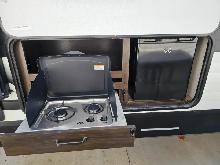 Enjoy outdoor cooking with this RV rental's built-in kitchen: a slide-out stove and fridge.. Grand Design Transcend Xplor 2022