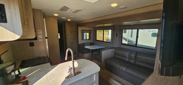 RV rental interior: A bright, modern camper with a full kitchen, sofa, and dinette. Ready for comfortable travel.. Forest River Aurora 2022