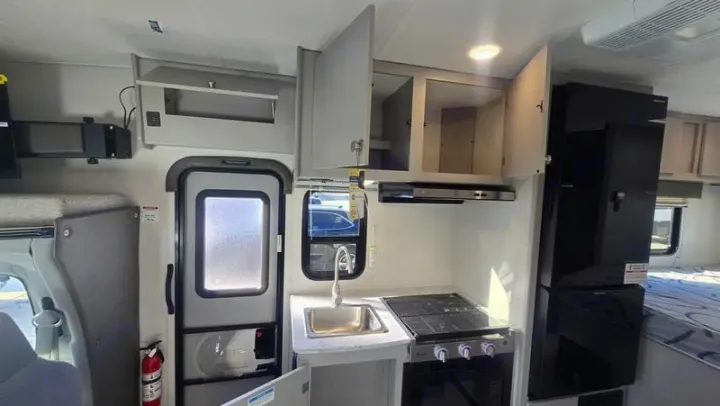 RV rental interior: full kitchenette with sink & stove, tall fridge, and cozy sleeping area for your travels.. Freelander 21QSS 2025