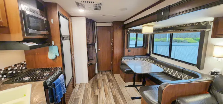 Spacious rv rental interior features a kitchen with microwave, stove, fridge, and a comfortable dining booth.. Jayco Jay Flight 2017